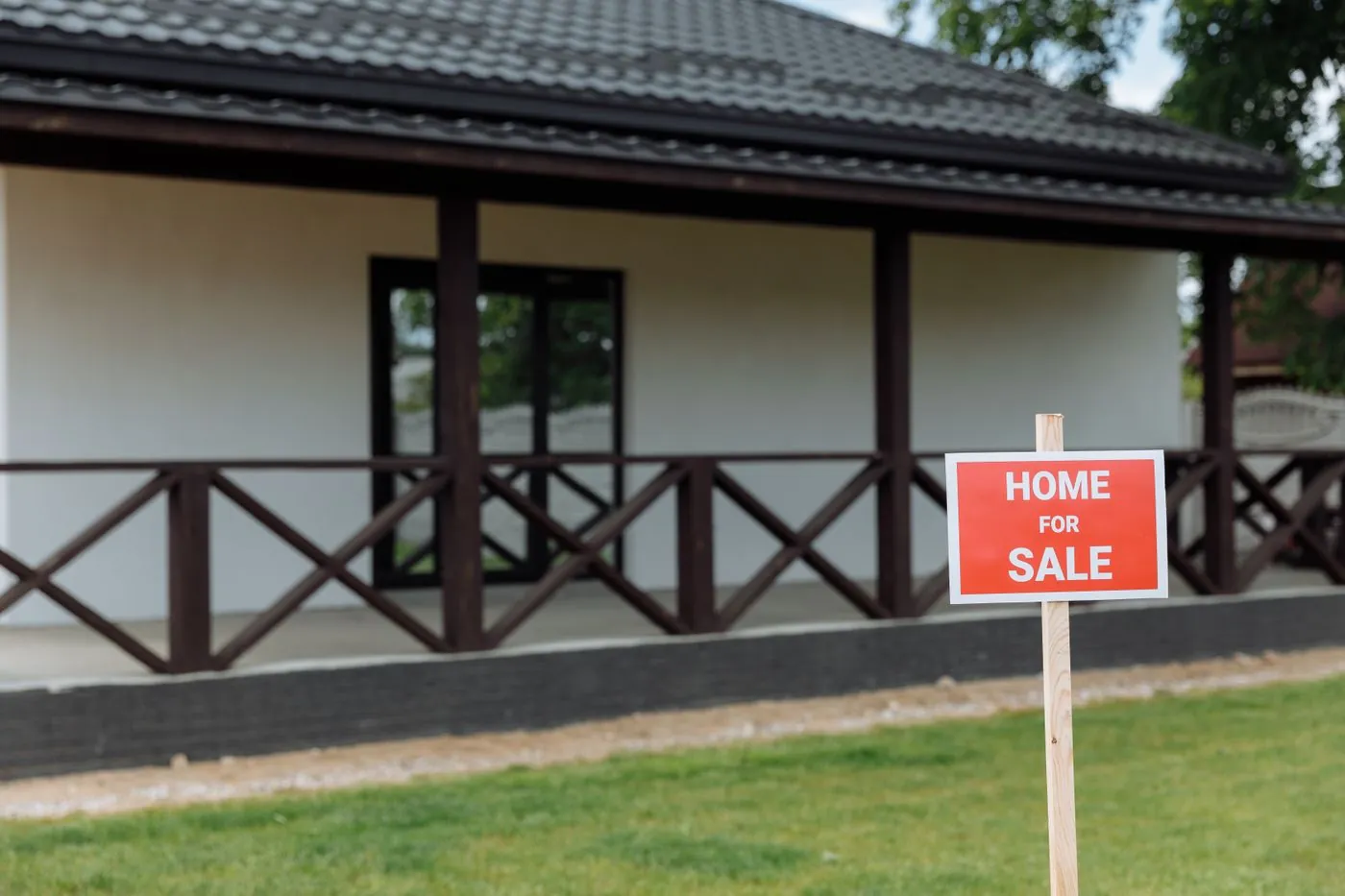 dům s cedulí Home for Sale na zahradě