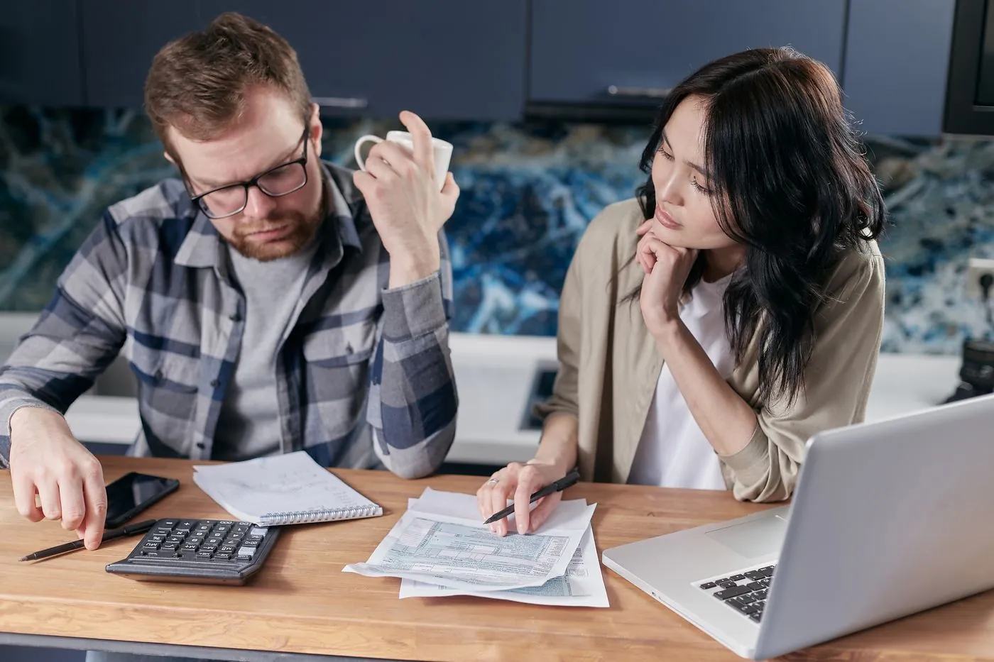Pár u laptopu společně řeší rodinné finance a účty