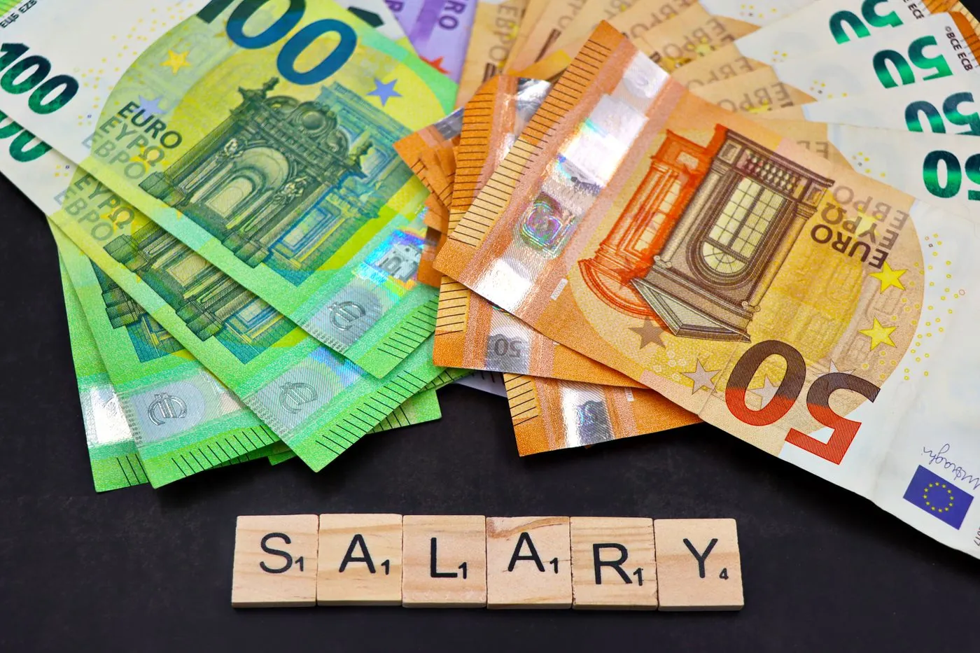 Eurové bankovky vedle dřevěných kostek s nápisem salary