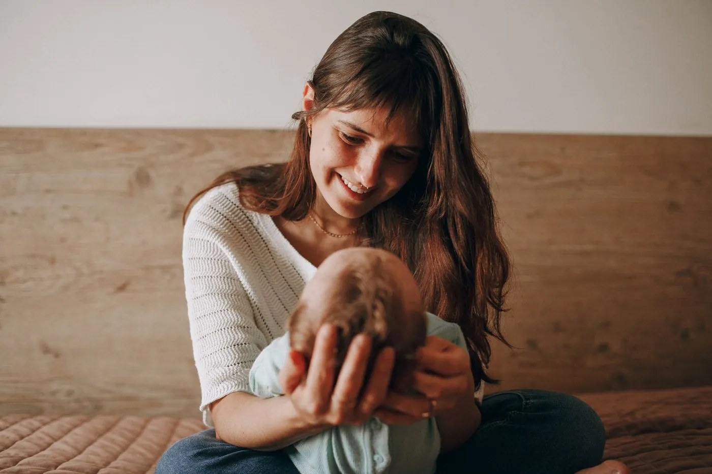 Žena láskyplně chová v rukou své miminko