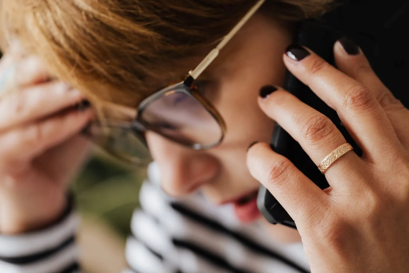 Žena znepokojeně telefonuje a dotýká se hlavy