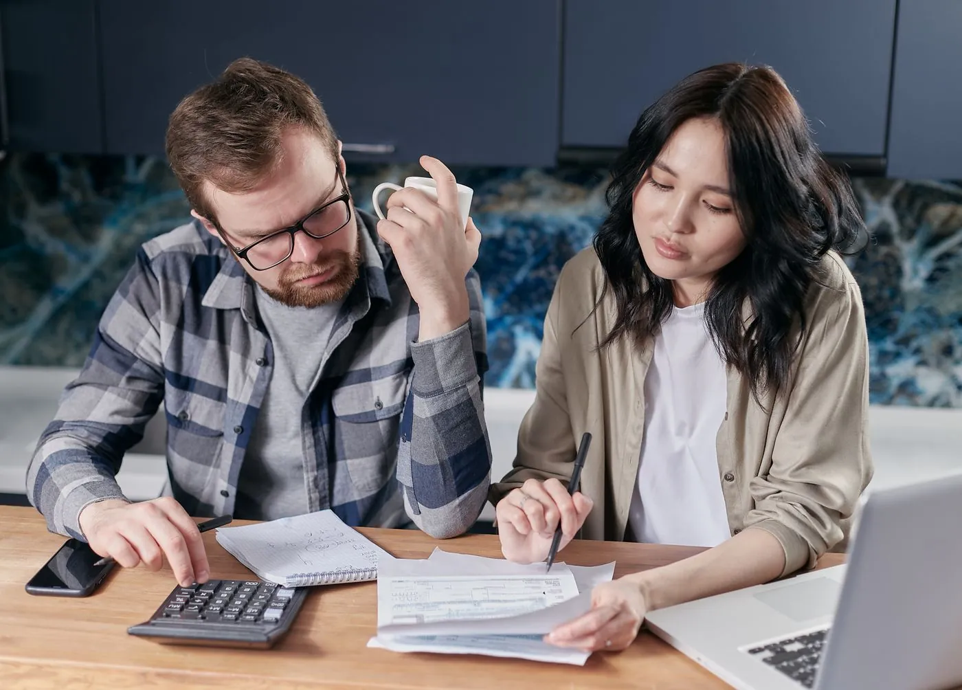 Pár společně řeší finance u stolu s kalkulačkou